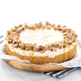 Gluten Free Chocolix No Bake Cheesecake recipe on a round wood board lined with wax paper.