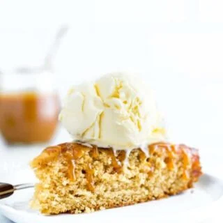 A slice of gluten free apple upside down cake topped with caramel sauce and vanilla ice cream