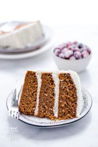 A slice of 3-layer gluten free gingerbread cake on a plate with a fork
