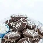 Chocolate Rice Krispies Treats are turned into Football Rice Krispie Treats for game day! They’re a chocolate treat base cut into football shapes then dipped in chocolate with white laces piped onto resemble footballs. This easy, no-bake dessert is perfect for tailgating, football parties, playoff games, and Superbowl parties. Game day desserts are the best part about game day foods so these are a must make dessert recipe! #gamedayfood #footballfood #ricekrispietreats #glutenfree #nobakedessert