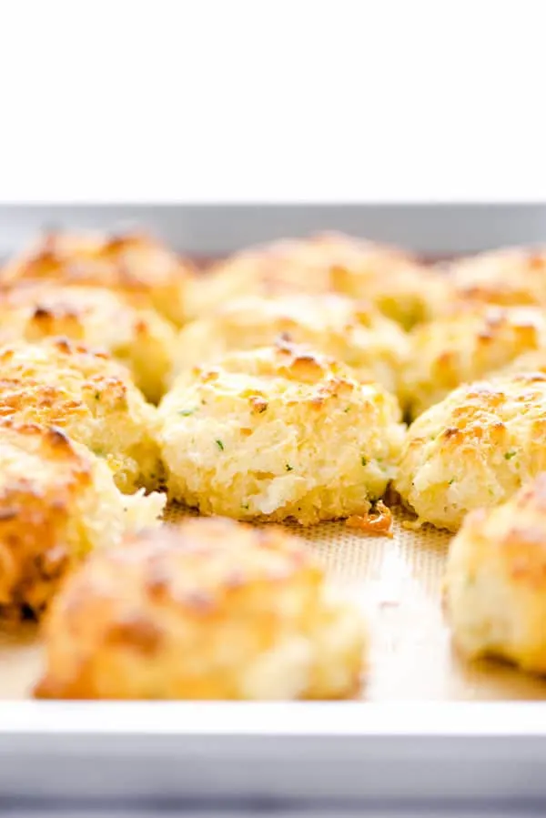 Gluten Free Cheddar Bay Biscuits on a Silpat lined half sheet pan
