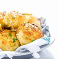 Gluten Free Cheddar Bay Biscuits in a towel lined silver serving bowl