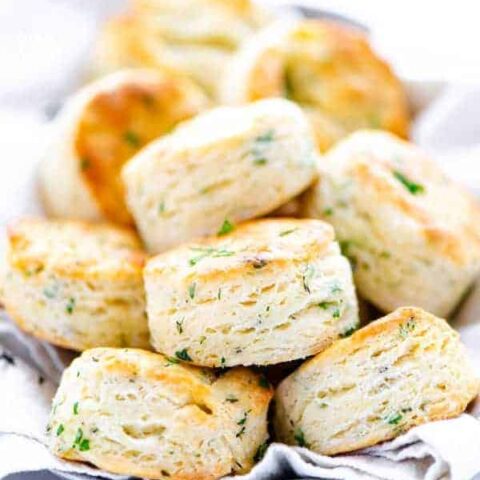 finished gluten free biscuits recipe with garlic and herbs featuring biscuits piled on a bread plate
