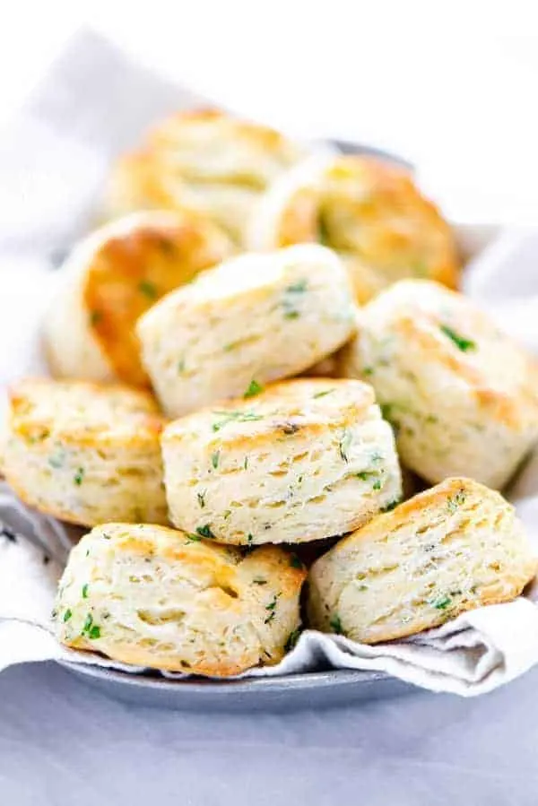 finished gluten free biscuit recipe with garlic and herbs featuring biscuits piled on a bread plate