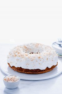 Gluten Free Coconut Pound Cake with Coconut Frosting and Toasted Coconut on a flat white cake plate