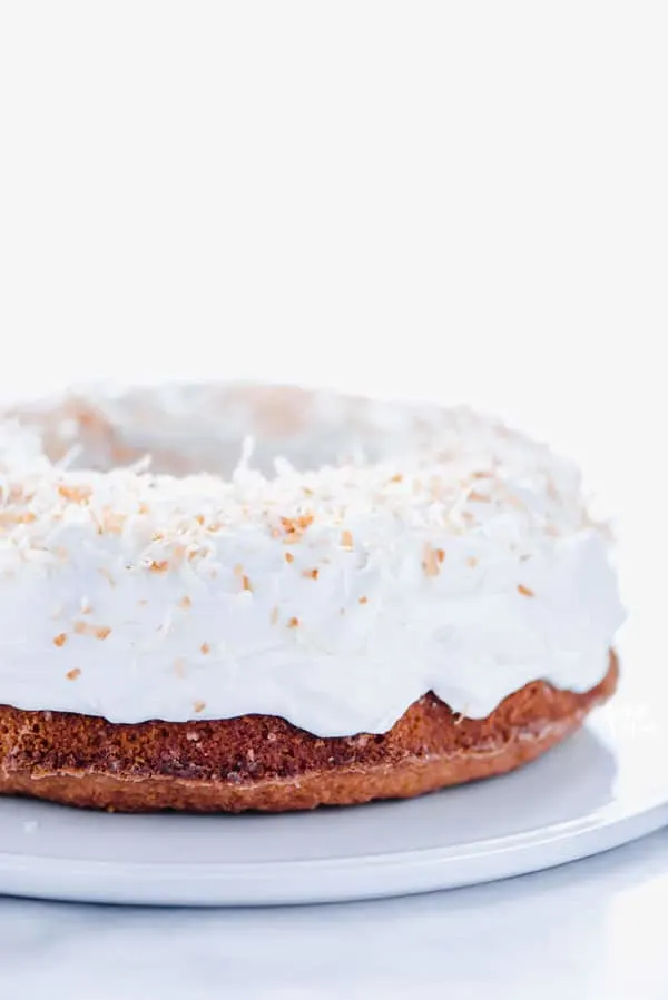 Gluten Free Coconut Pound Cake with Coconut Frosting on a white cake plate