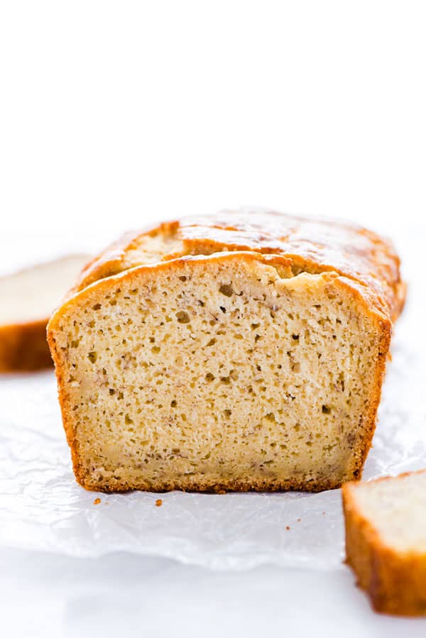 A loaf of Gluten Free Sourdough Banana Bread sliced on a piece of wax paper