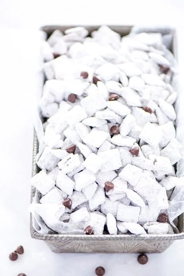 Super simple Gluten Free Puppy Chow - AKA Muddy Buddies is everyone’s favorite sweet snack. You only need a few ingredients to make it - Chex cereal, chocolate chips, butter, vanilla, peanut butter, and powdered sugar. You can even make vegan muddy buddies by using vegan butter and dairy free chocolate chips. This no bake recipe takes less than 15 minutes to make too! The recipe calls for semi-sweet chocolate but you can use milk chocolate or dark chocolate if you prefer.