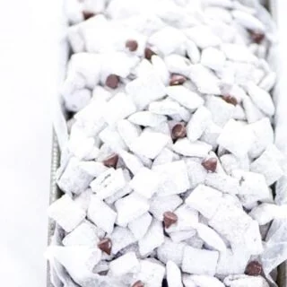 Super simple Gluten Free Puppy Chow - AKA Muddy Buddies is everyone’s favorite sweet snack. You only need a few ingredients to make it - Chex cereal, chocolate chips, butter, vanilla, peanut butter, and powdered sugar. You can even make vegan muddy buddies by using vegan butter and dairy free chocolate chips. This no bake recipe takes less than 15 minutes to make too! The recipe calls for semi-sweet chocolate but you can use milk chocolate or dark chocolate if you prefer.