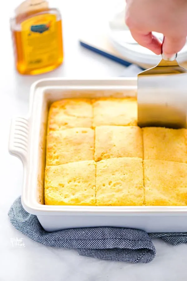 a gluten free sourdough cornbread recipe being cut with a square spatula/server