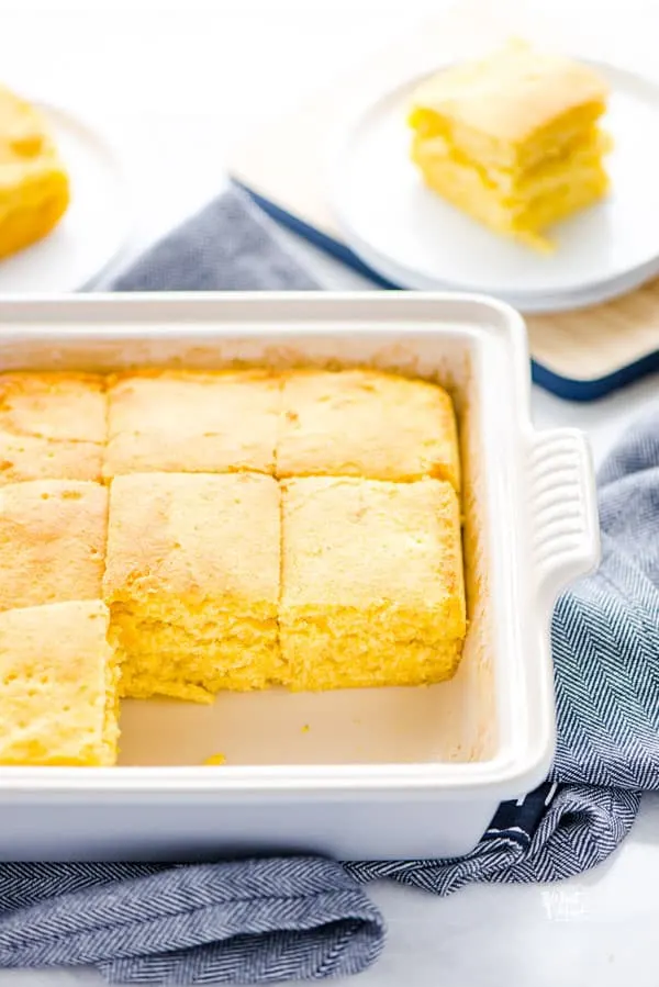 cut gluten free sourdough cornbread in a square baking dish with 2 pieces removed