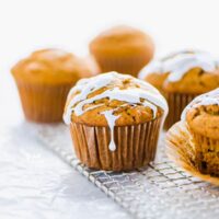 Gluten free sweet potato muffins on a small wire rack topped with marshmallow glaze