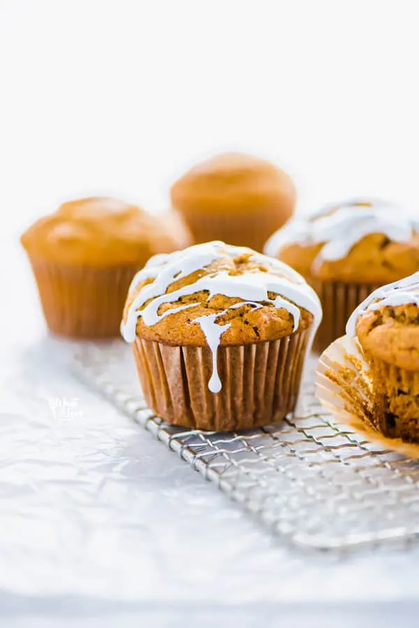 Gluten free sweet potato muffins on a small wire rack topped with marshmallow glaze