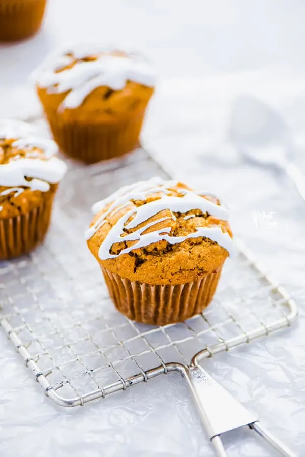 Gluten Free Sweet Potato Muffins on a wire rack topped with a drizzle of marshmallow glaze