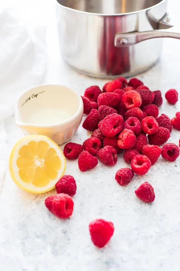 Fresh raspberries and lemon ready to be turned into raspberry sauce