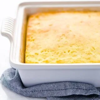 A fully baked gluten free sourdough cornbread recipe still in the pan on top of a blue towel