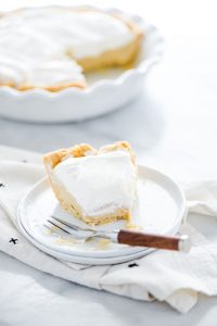 a piece of maple cream pie on a white plate with a bite taken out