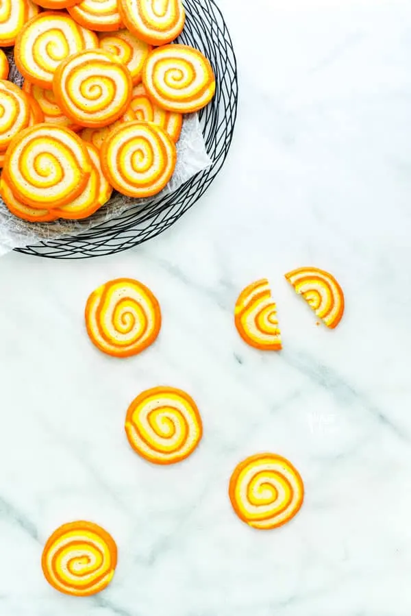 overhead shot of gluten free candy corn pinwheel cookies on a white marble surface