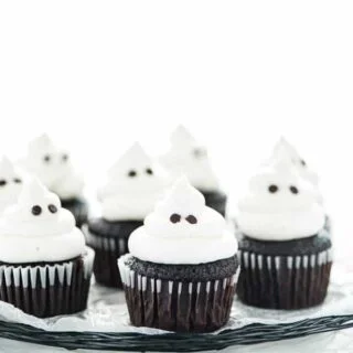 gluten free Halloween ghost cupcakes on a black wire platter lined with wax paper