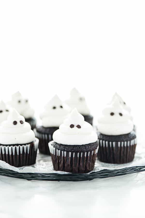 gluten free Halloween ghost cupcakes on a black wire platter lined with wax paper