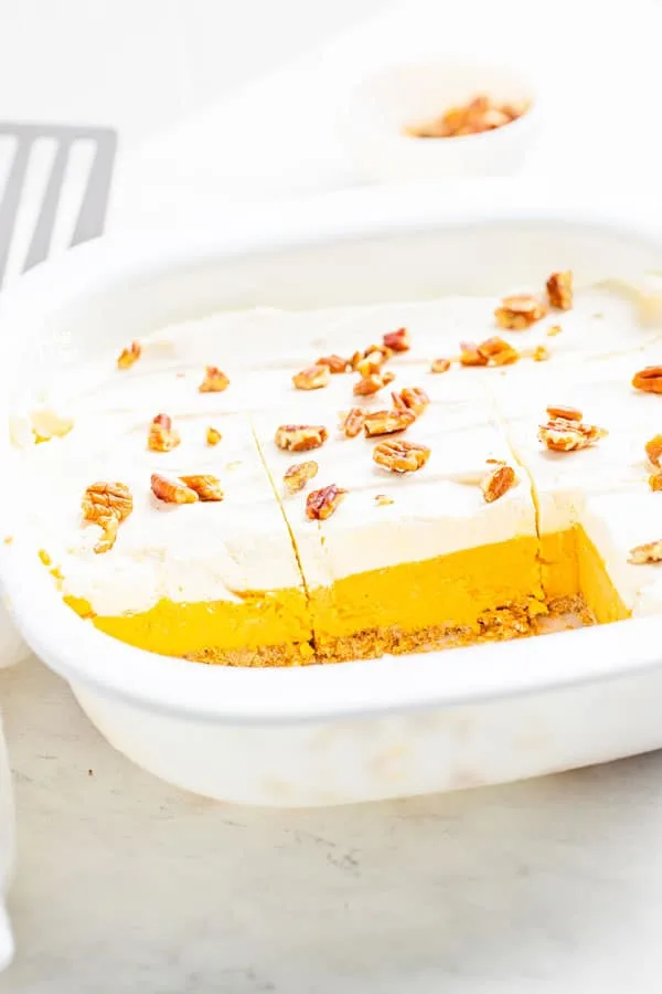 Gluten free pumpkin lush cake in a white pan that's been cut into