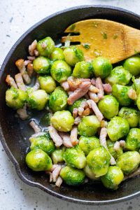 Sautéed Brussels Sprouts with Bacon being cooked in a cast iron skillet