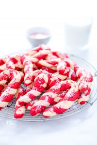 a pile of gluten free candy cane cookies on a round. metal wire rack