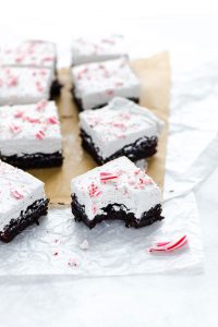 gluten free peppermint brownies on unbleached parchment paper with one brownie that's been bitten