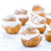 gluten free Choux Pastry shells filled with whipped cream and topped with powdered sugar for Cream Puffs