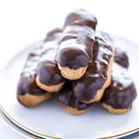 baked and stacked gluten free chocolate eclair recipe ready to serve on a white plate