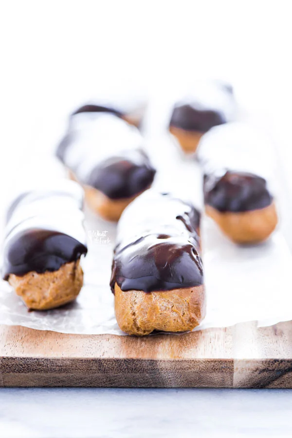 gluten free eclairs on a wax paper lined wood cutting board