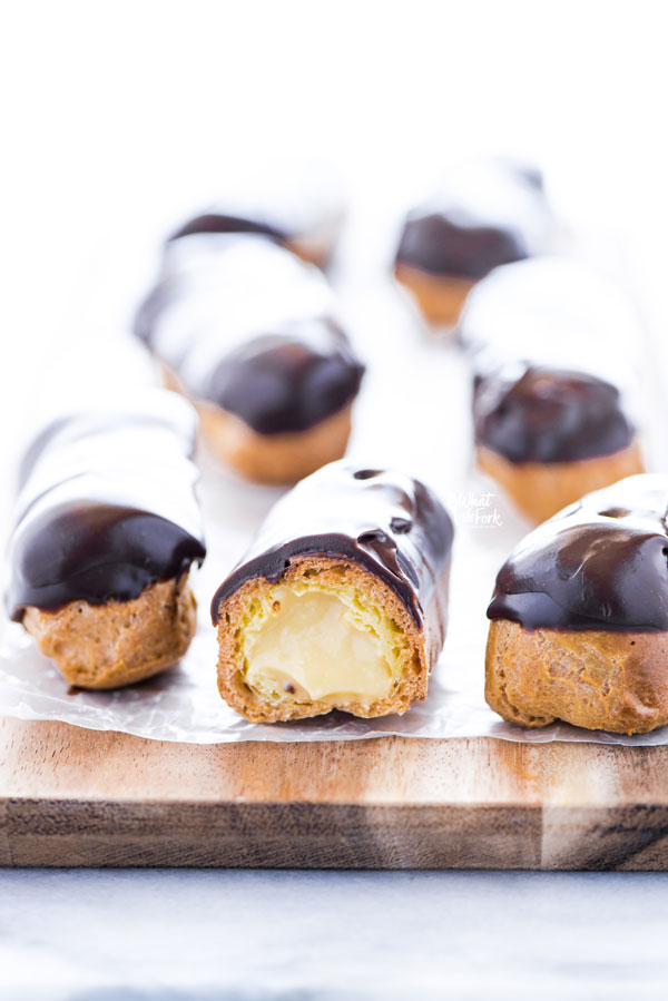 a gluten free chocolate eclair cut in half to show the pastry cream in the center