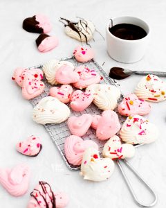 baked heart meringue cookies on a small wire rack
