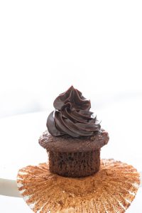 chocolate ganache pipped onto a chocolate cupcake