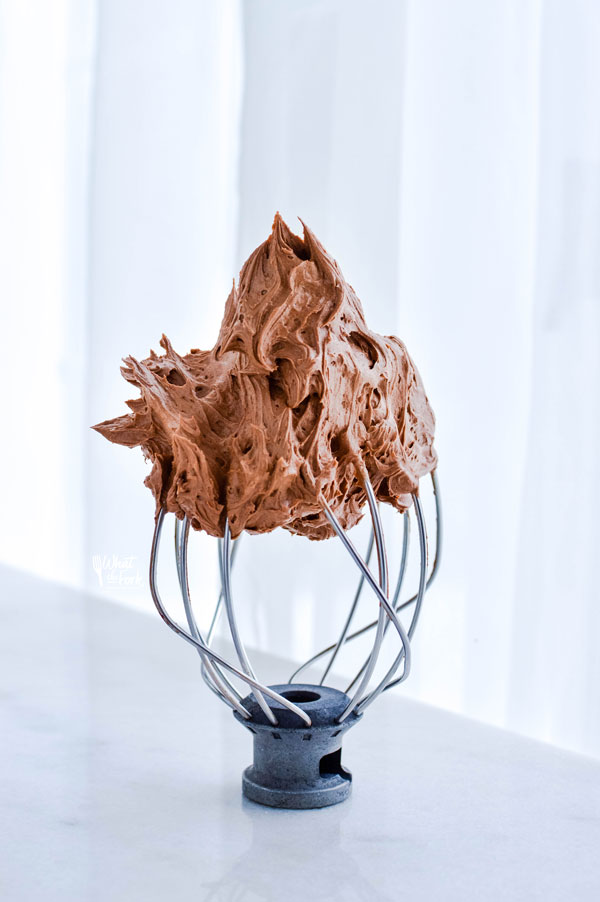 whipped chocolate ganache on a metal stand mixer whisk