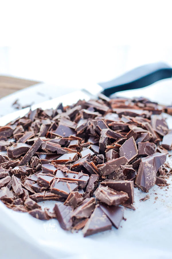 chopped chocolate on a marble cutting board ready to be used in a chocolate ganache recipe