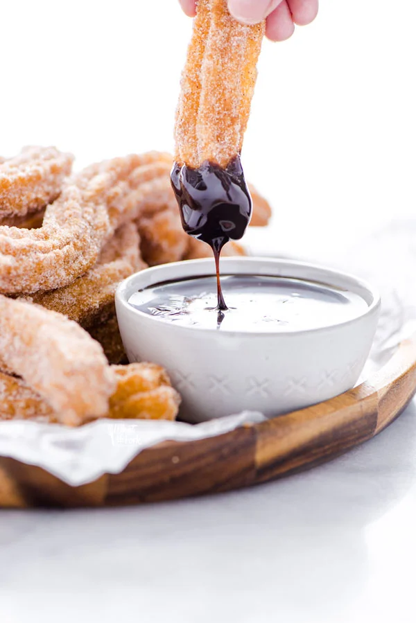 a gluten free churro that's been dipped in chocolate sauce