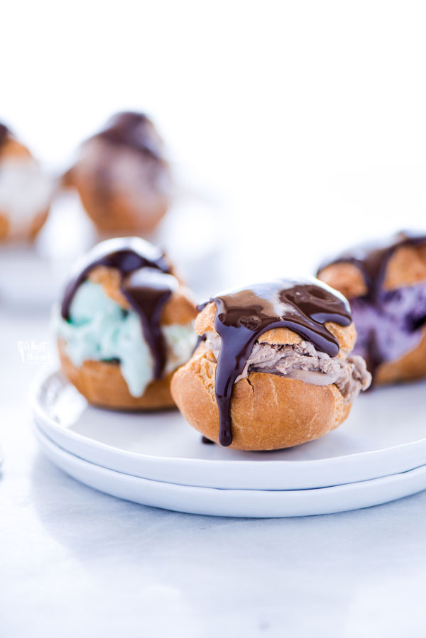 Gluten Free profiteroles on a stack of white plates ready to be served