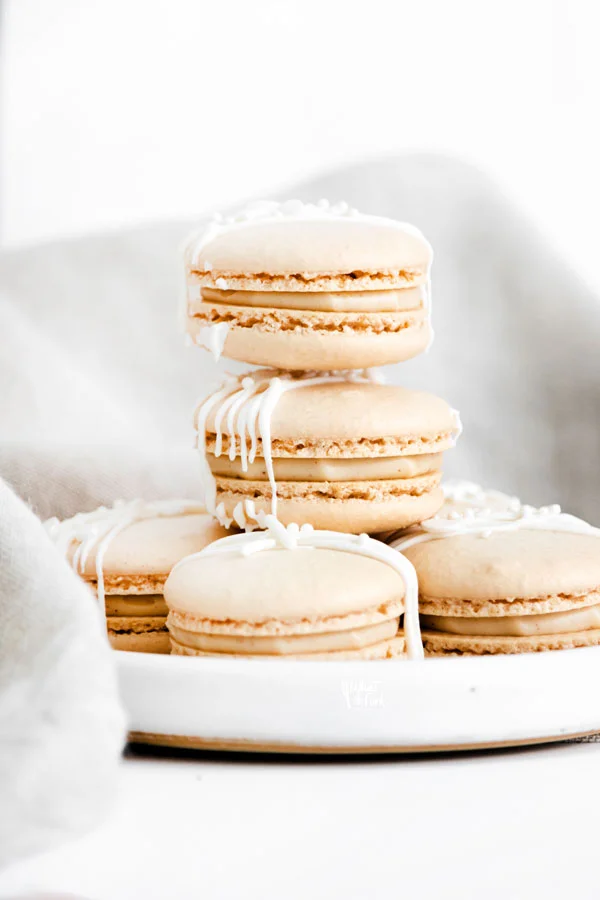 a baked Baileys Irish Cream Macaron Recipe with macarons stacked on a small white plate
