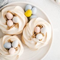 overhead shot of Easter Meringue Nests on a white plate with mini Cadbury Eggs