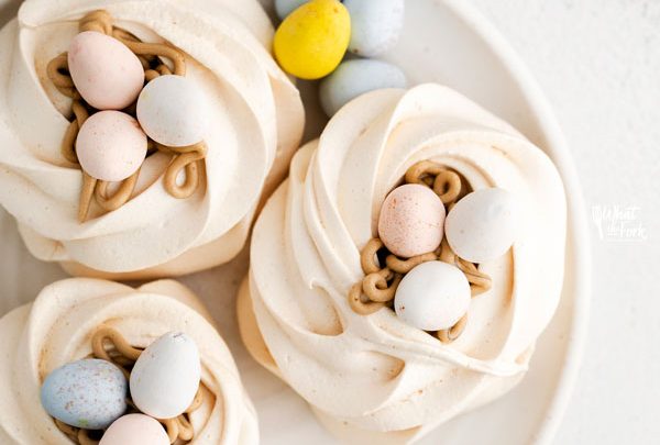 overhead shot of Easter Meringue Nests on a white plate with mini Cadbury Eggs
