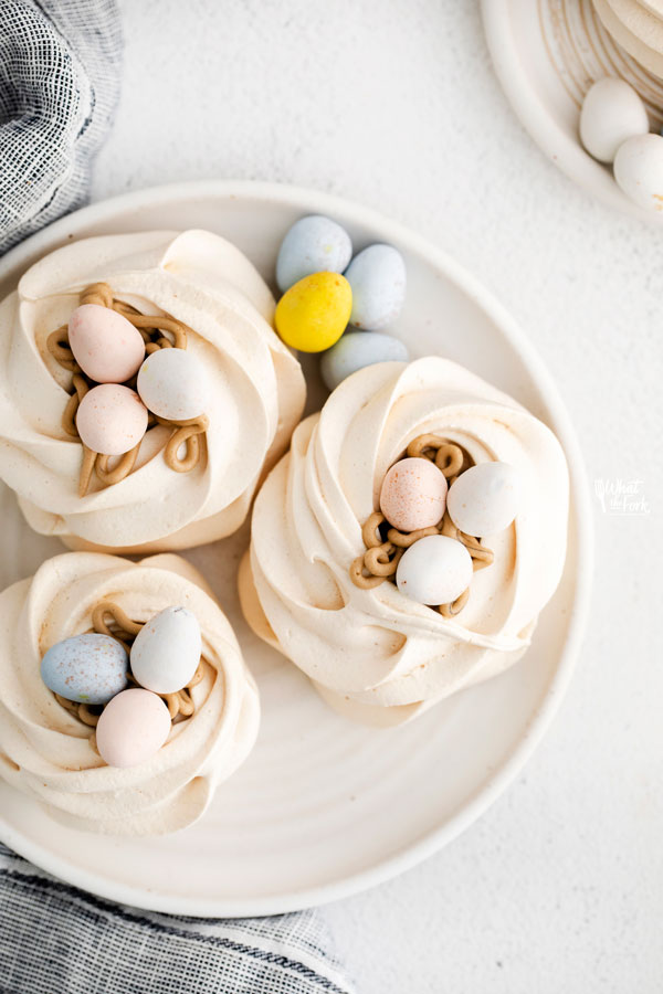 overhead shot of Easter Meringue Nests on a white plate with mini Cadbury Eggs