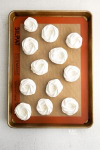 overhead shot of baked Easter Meringue Nests on a Silpat lined half sheet pan