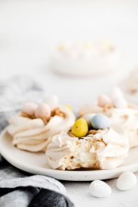 Easter Meringue Nests on a white plate with a bite taken out of one