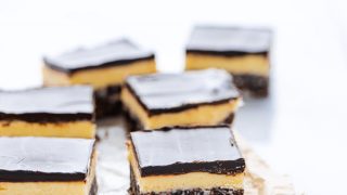 sliced Gluten Free Nanaimo Bars on top of brown parchment paper and wax paper