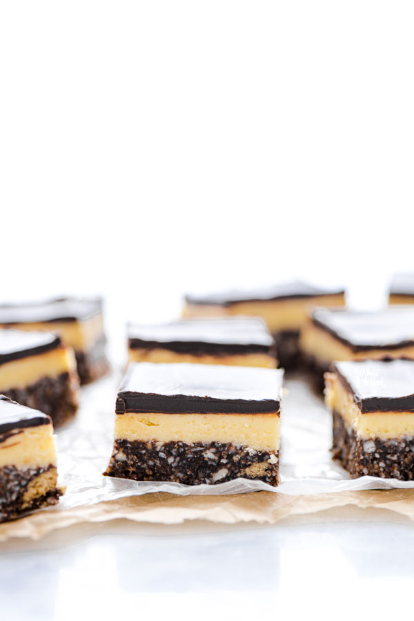 sliced Gluten Free Nanaimo Bars on top of wax paper lined parchment paper