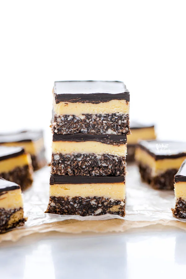 Gluten Free Nanaimo Bars stacked on top of parchment paper