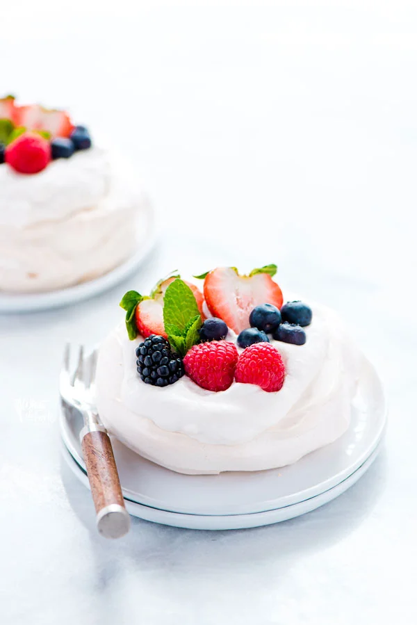 a mini pavlova on a stack of white plates