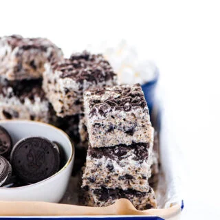 Gluten Free Cookies and Cream Rice Krispie Treats stacked on an enamel tray lined with unbleached parchment paper