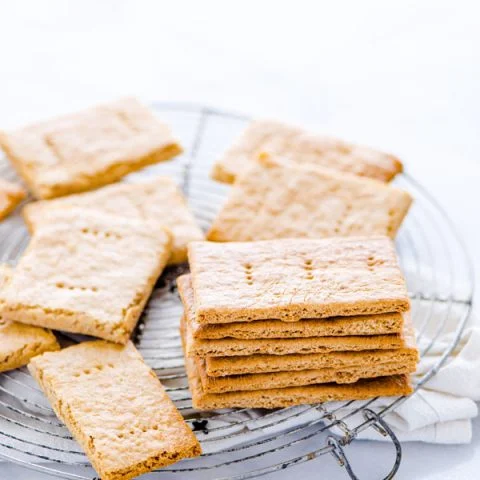 gluten free graham crackers stacked and piled on a round wire metal cooling rack